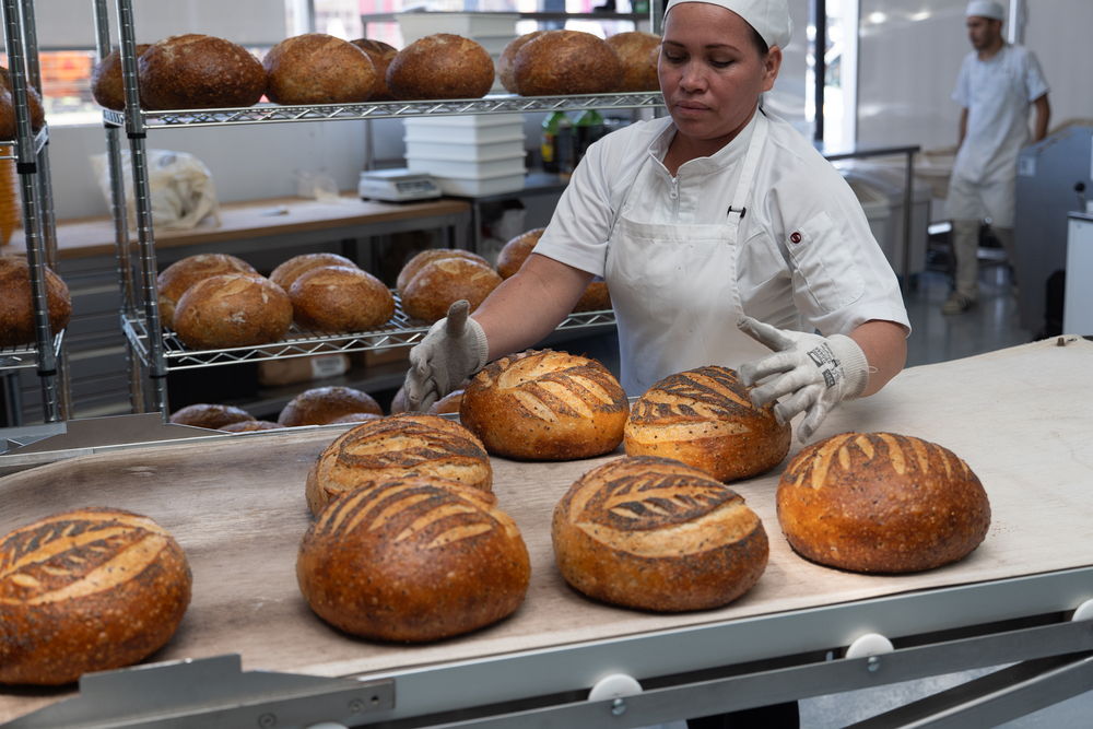 Panadera acomodando las hogazas recién horneadas